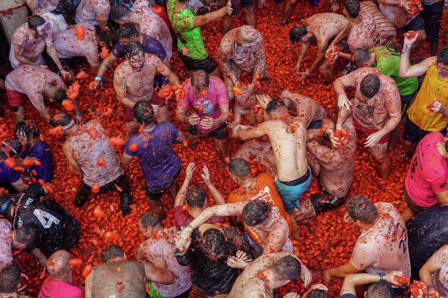 Revellers throw tomatoes at each other during the annual "Tomatina", tomato fight fiesta in the village of Bunol near Valencia, Spain, Wednesday, Aug. 31, 2022. Alberto Saiz/AP