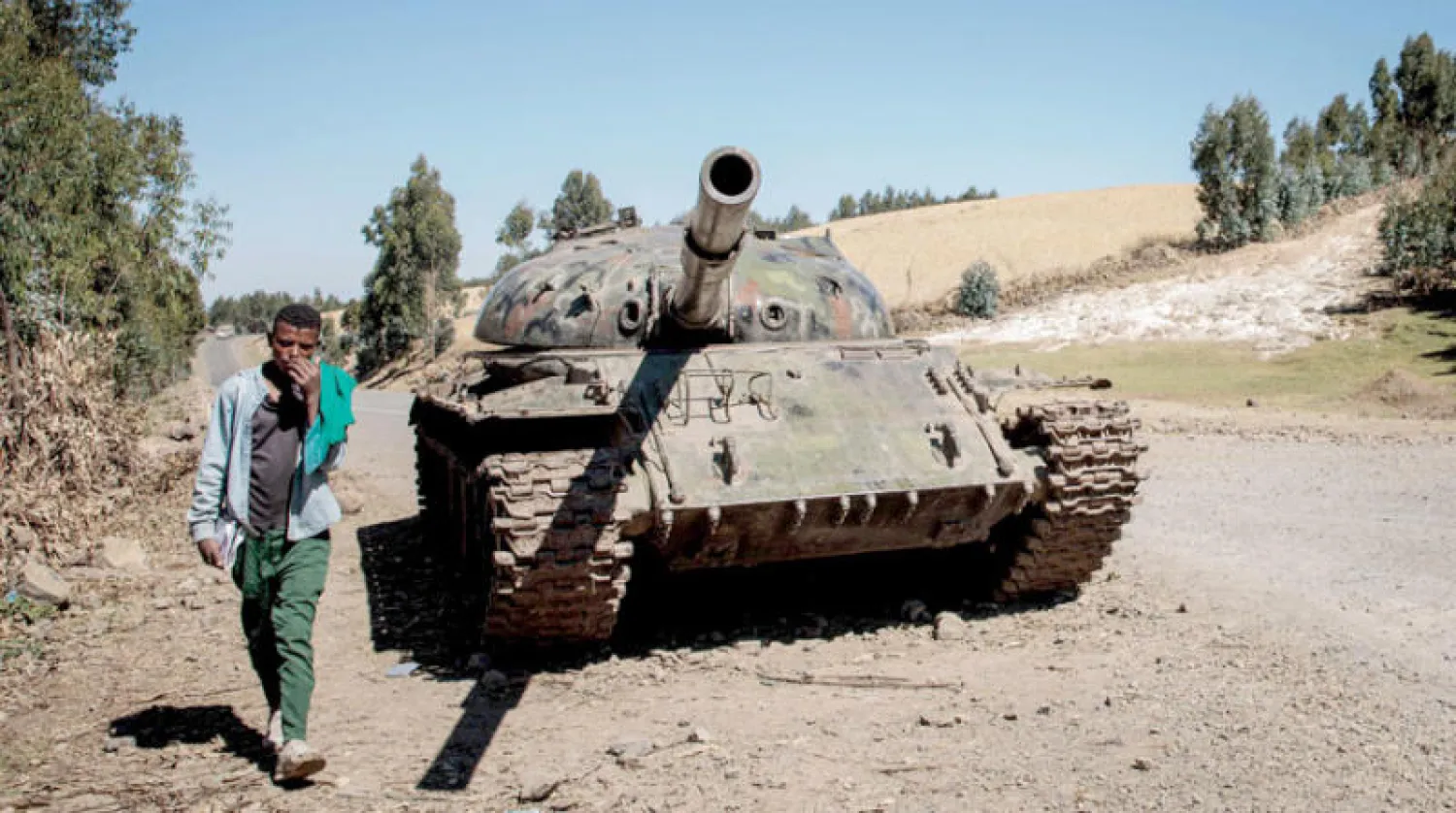 شاب إثيوبي يسير بجوار دبابة ضمن مواجهات بين الحكومة و«تيغراي» عام 2021 (أ.ف.ب)