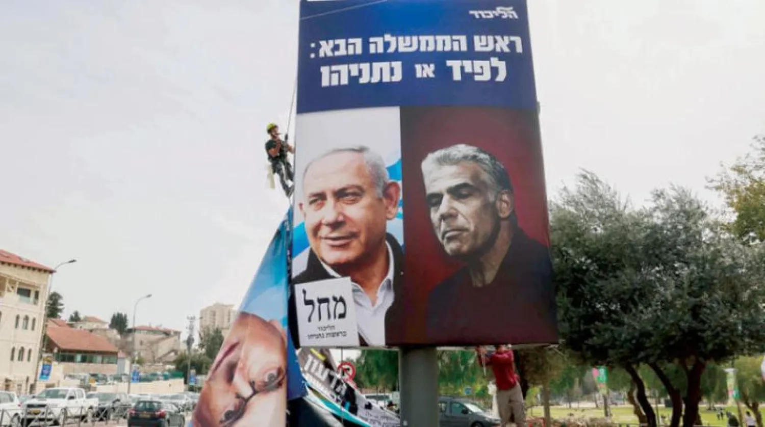 Mart 2021’de İsrail Başbakanı Binyamin Netanyahu (solda) ve rakibi Yeş Atid Partisi lideri Yair Lapid'in yer aldığı seçim afişi (AFP)