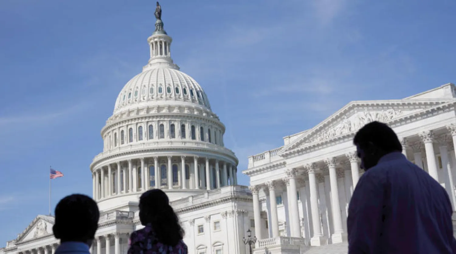 عابرون أمام مقر الكونغرس في الكابيتول وسط واشنطن العاصمة في يونيو الماضي (أ.ب)