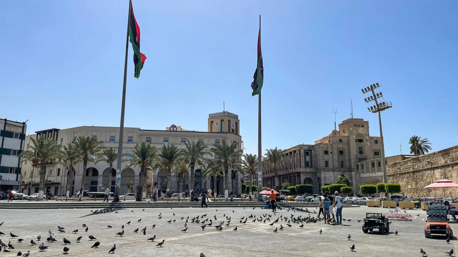 Youths feed pigeons at the Martyrs' Square in the center Libya's capital Tripoli on August 29, 2022. (AFP)