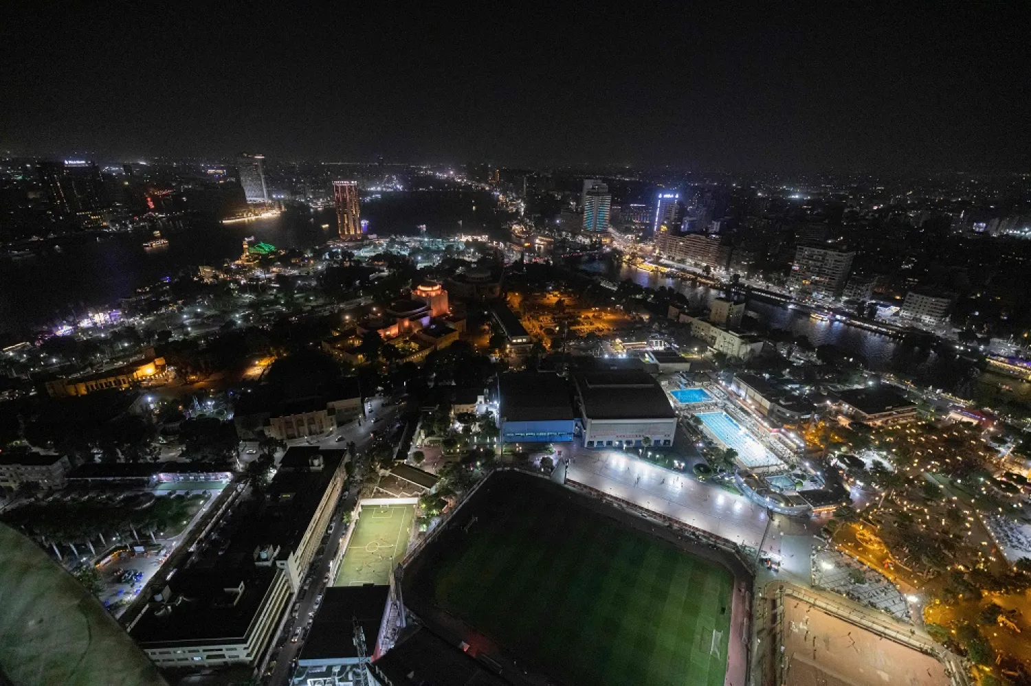 This picture taken on August 24, 2022 from the landmark Cairo Tower shows a night-time view of the Cairo Opera House (C) with the Ahly SC football club grounds (bottom) in the Zamalek district and the Garden City and Manial districts (top L) of Egypt's capital Cairo; and the Agouza and Dokki districts (top R) of the twin-city Giza. (AFP)