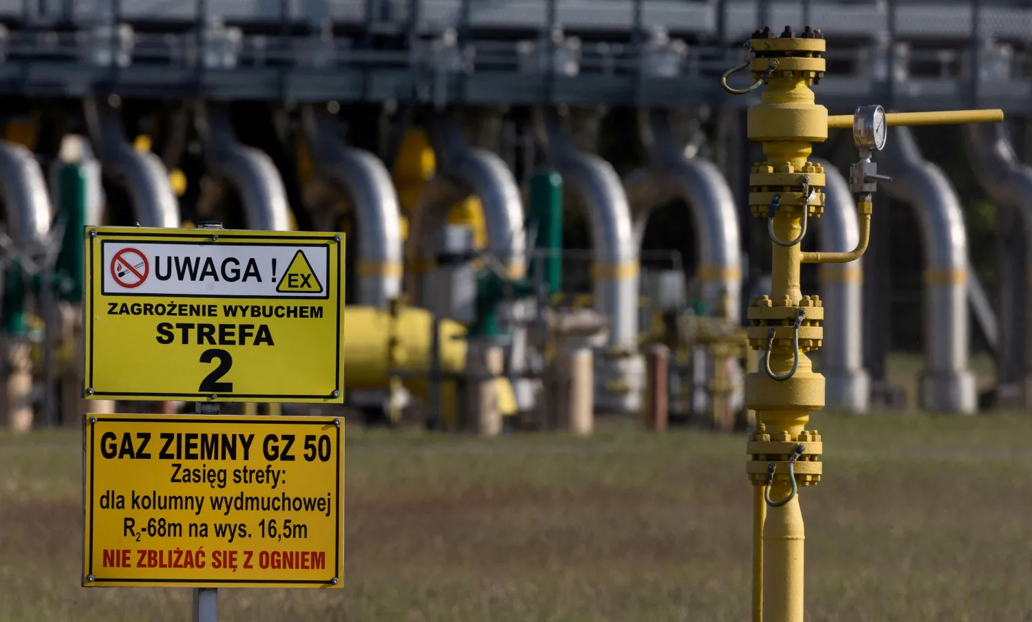 Warning signs are pictured in front of the gas compressor station, a part of Polish section of the Yamal pipeline that links Russia with western Europe which is owned by a joint venture of Gazprom and PGNiG but it is operated by Poland's state-owned gas transmission company Gaz-System, in Gabinek near Wloclawek, Poland May 23, 2022. The signs read: "Attention! Explosion risk. Zone 2" and "Natural gas. Keep fire away." REUTERS/Kacper Pempel/File Photo


