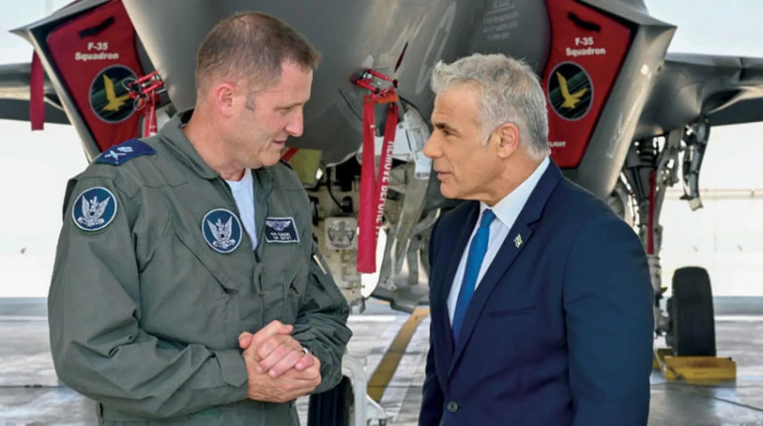 صورة وزعتها الحكومة الإسرائيلية للبيد وقائد سلاح الجو اللواء تومير بار في قاعدة «نيفاتيم» الجوية أمس