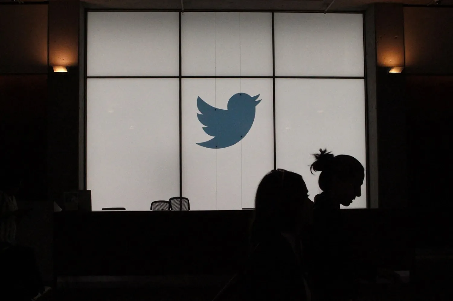 In this file photo taken on August 13, 2019, employees walk past a lighted Twitter log as they leave the company's headquarters in San Francisco. (AFP)