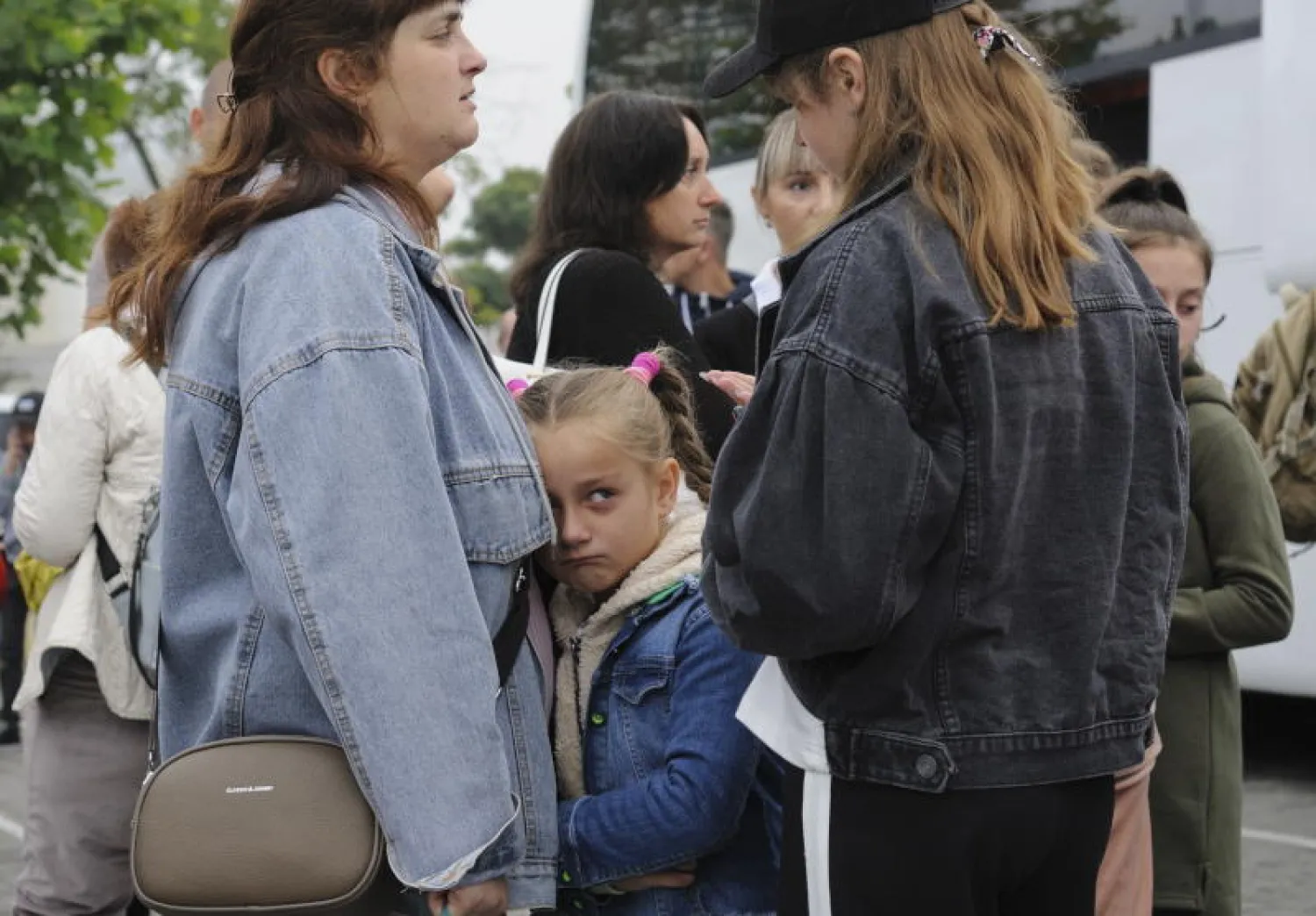 أطفال يودعون أقاربهم قبل نقلهم من أوكرانيا إلى فرنسا (إ.ب.أ)