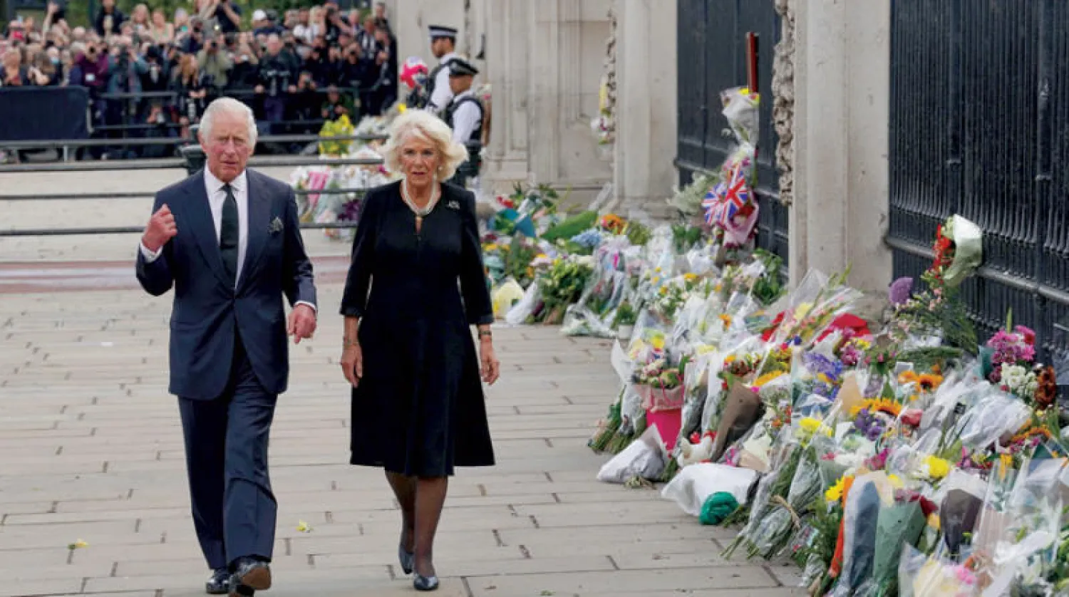 الملك تشارلز الثالث وزوجته كاميلا قبل دخولهما إلى قصر باكنغهام أمس (رويترز)