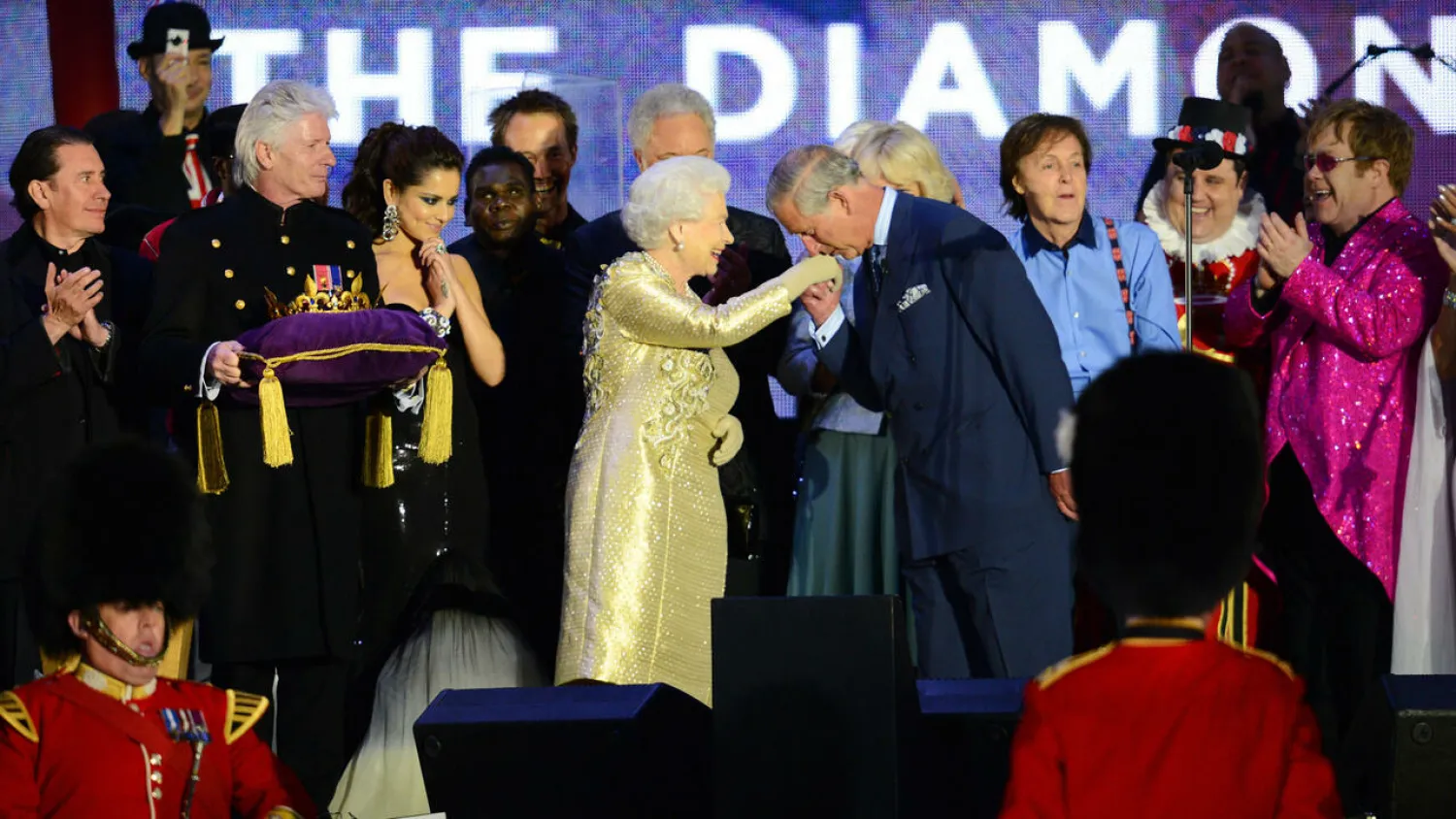 Prince Charles kisses the hand of Queen Elizabeth II on stage as British singers Paul McCartney and Elton John look on after the Diamond Jubilee concert in June 2012 Leon NEAL AFP/File

