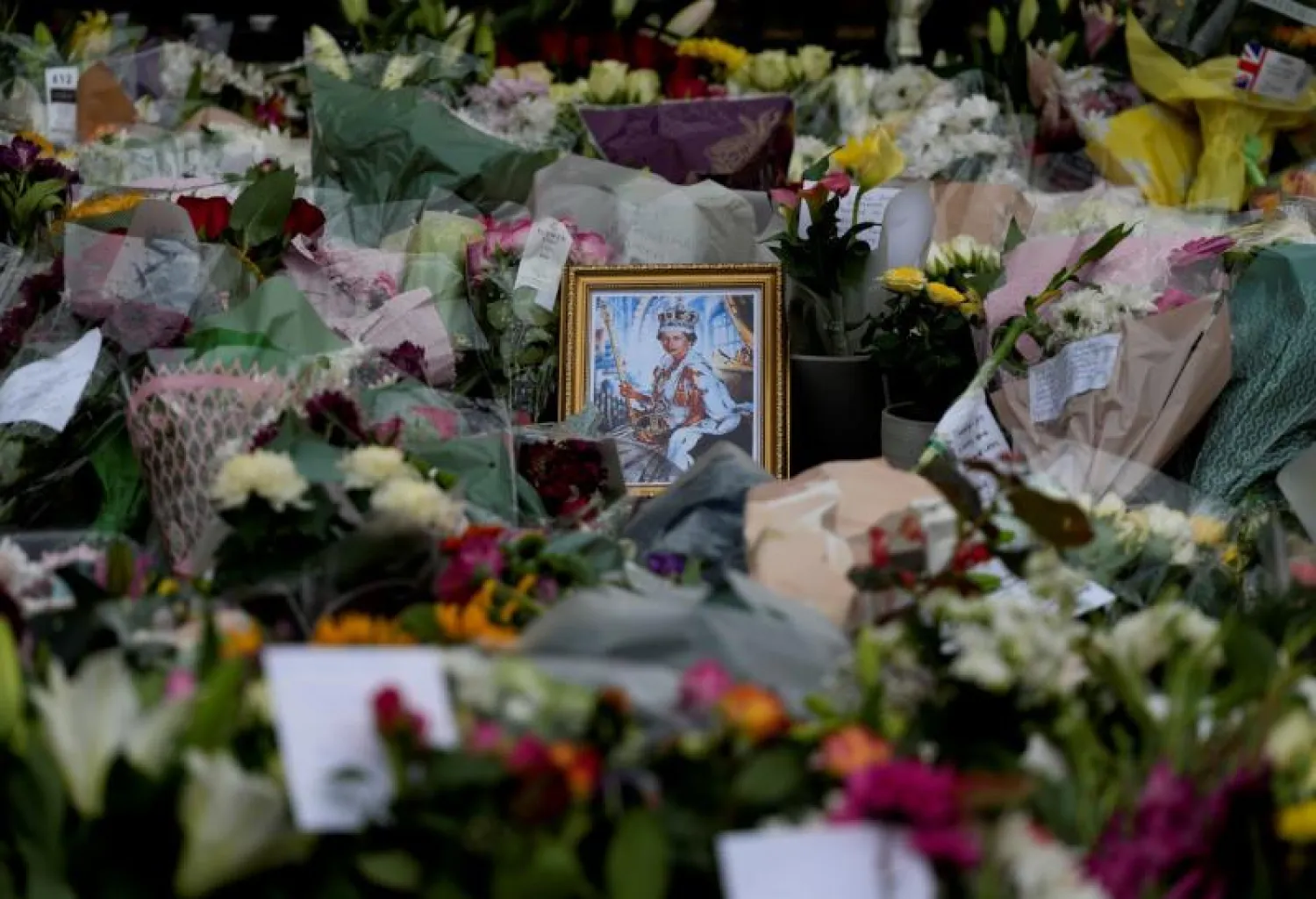 زهور حول صورة للملكة إليزابيث الثانية خارج قلعة وندسور (أ.ب)