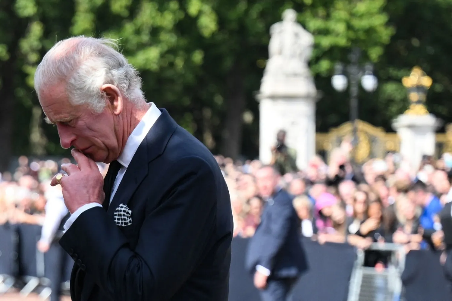 Britain's King Charles III looks at floral tributes left outside of Buckingham Palace in London, on September 9, 2022, a day after Queen Elizabeth II died at the age of 96. (AFP)