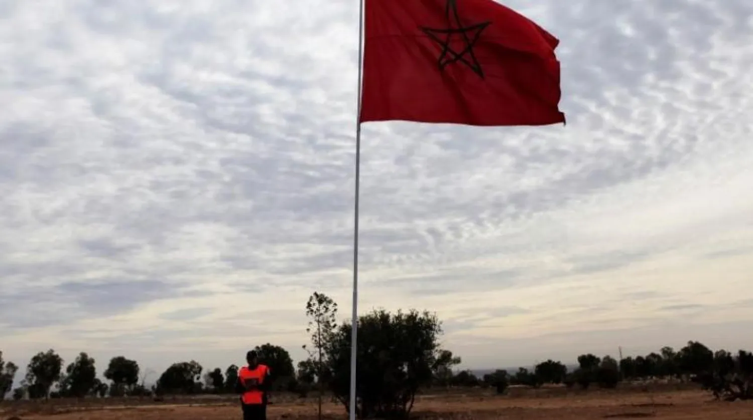 File photo of a police officer standing near a Moroccan national flag. REUTERS/Amr Abdallah Dalsh
