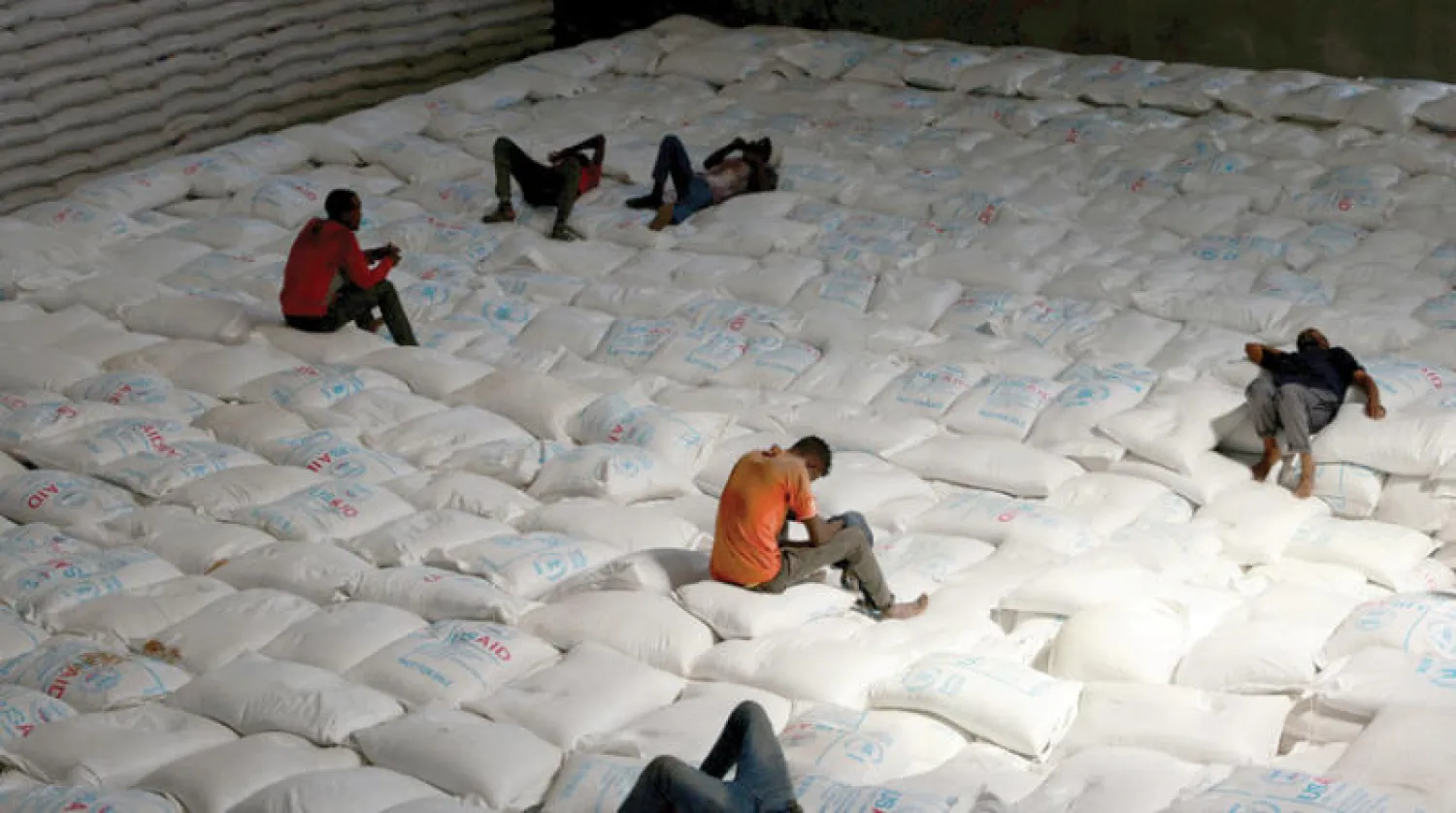 عمال يأخذون فترة راحة خلال تفريغ مساعدات غذائية مرسلة من أوكرانيا في مخزن لبرنامج الغذاء العالمي ببلدة أدما الإثيوبية يوم 8 سبتمبر الحالي (رويترز)