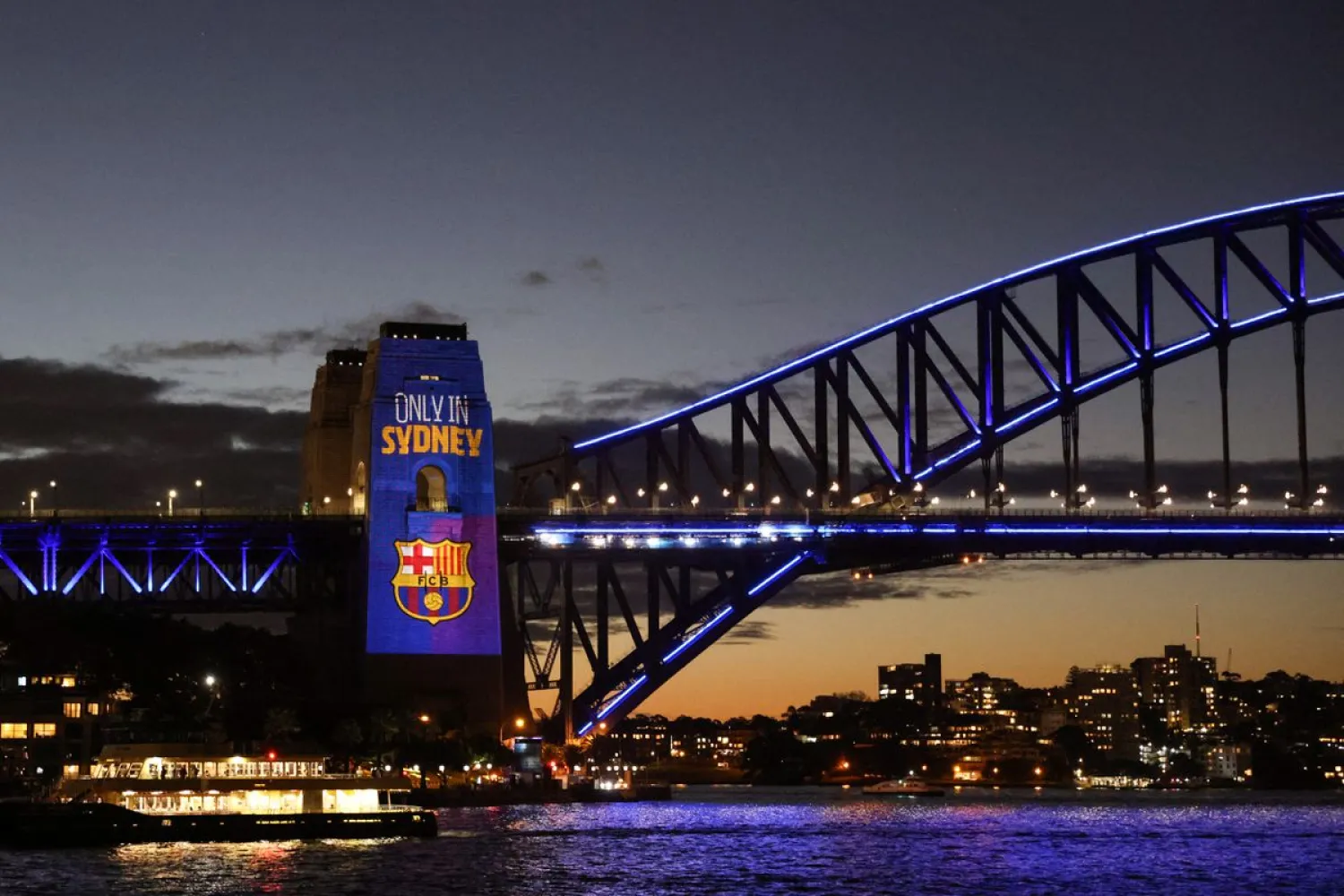A projection of the FC Barcelona logo is seen on the Sydney Harbor Bridge as the squad visits Australia for a friendly soccer match against the A-League All-Stars, in Sydney, Australia, May 24, 2022. REUTERS/Loren Elliott

