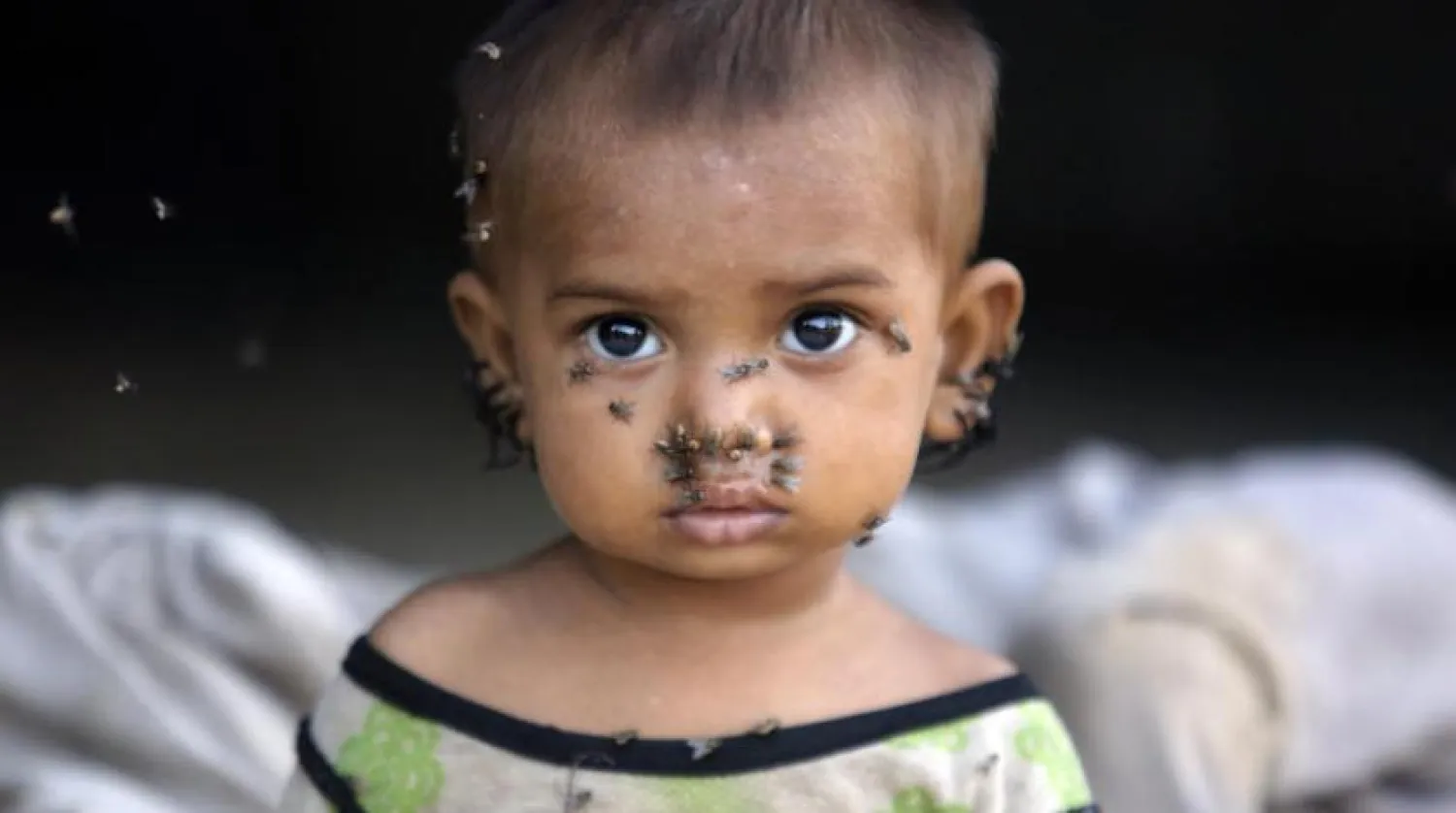 Pakistan'daki sel mağdurları için derme çatma bir kampta bir çocuk kameraya bakıyor (AP)