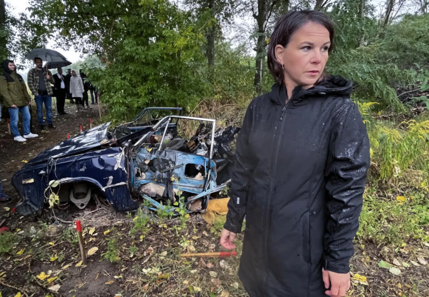 وزيرة الخارجية الألمانية أنالينا بيربوك قرب سيارة دمرها لغم روسي في منطقة قريبة من كييف (د.ب.أ)