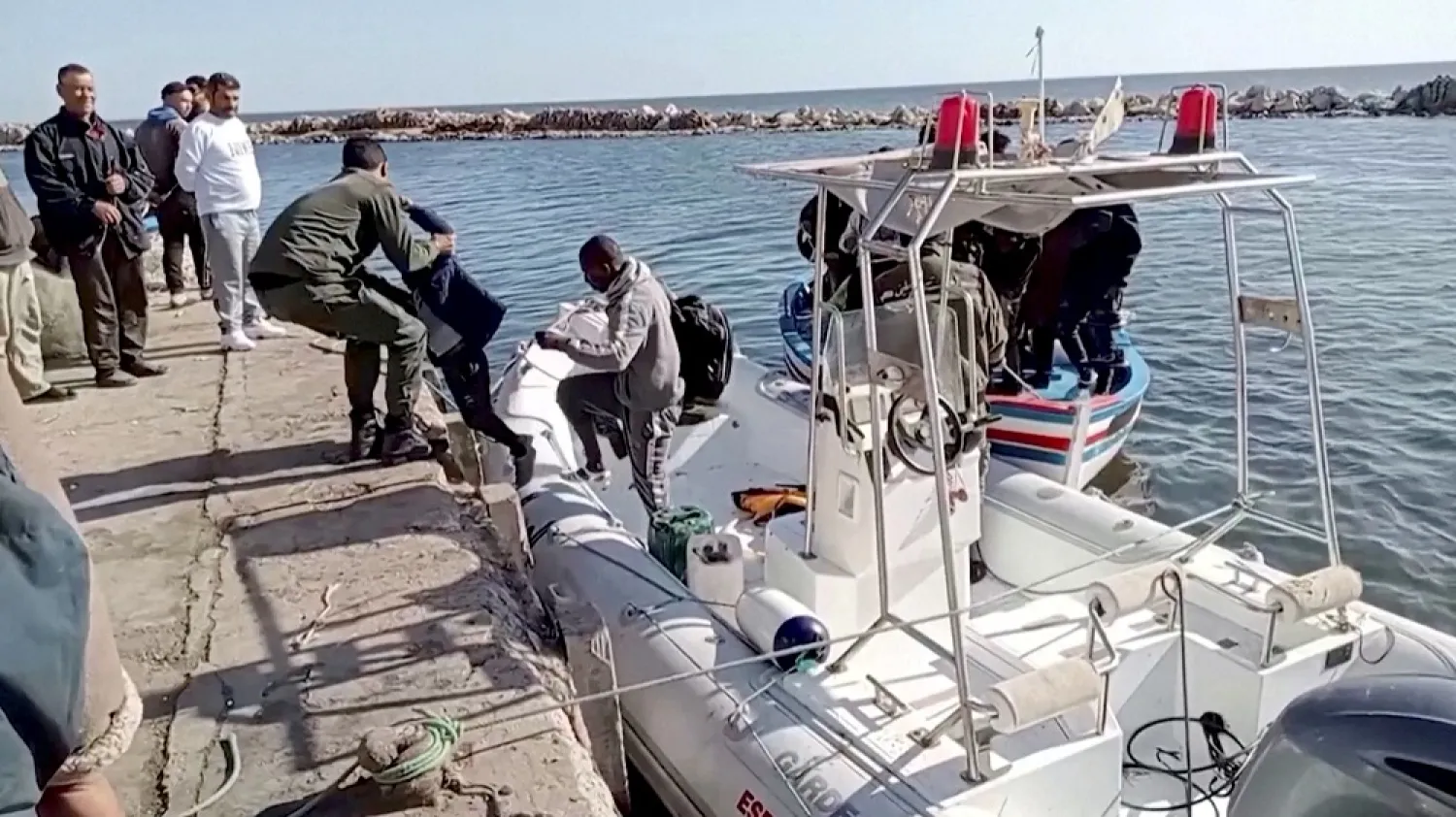 A Tunisian national coast guard helps a migrant child to get off a rescue boat in Jbeniana, Safx, Tunisia April 23, 2022, in this screen grab taken from a handout video taken April 23, 2022. (Wahid Dahech/ Handout via Reuters)