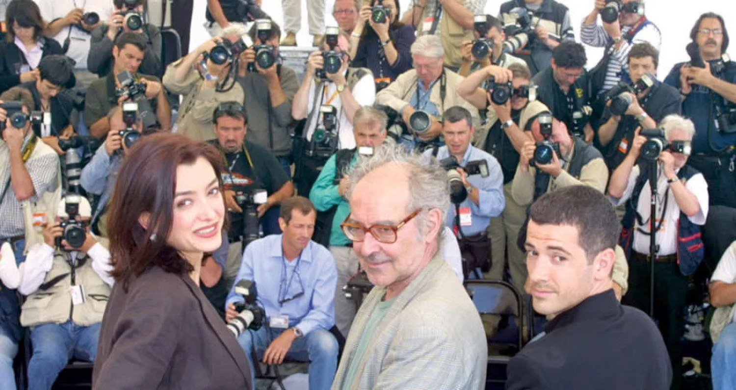 جان لوك غودار والممثلان الفرنسيان برونو بوتزولو وسيسيل كامب (أ.ف.ب)