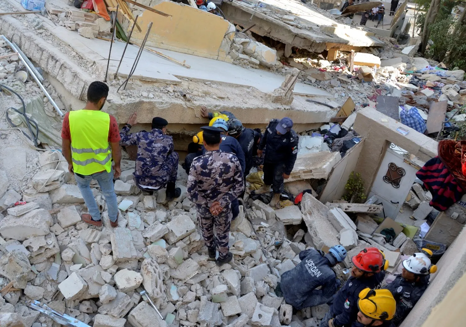 Rescuers search for survivors under the rubble of a collapsed building in Amman, Jordan September 14, 2022. (Reuters)