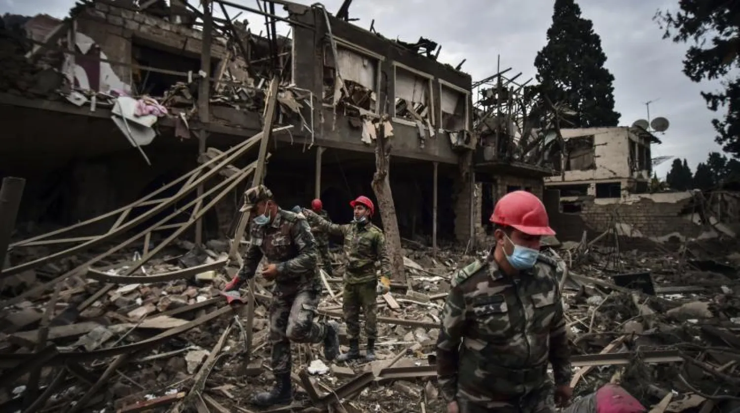 Azerbaijani soldiers and firefighters search for survivors after rocket fire overnight by Armenian forces, early Sunday, Oct. 11, 2020, in a residential area in Ganja, Azerbaijan's second largest city, near the border with Armenia. (Ismail Coskun/IHA via AP)

