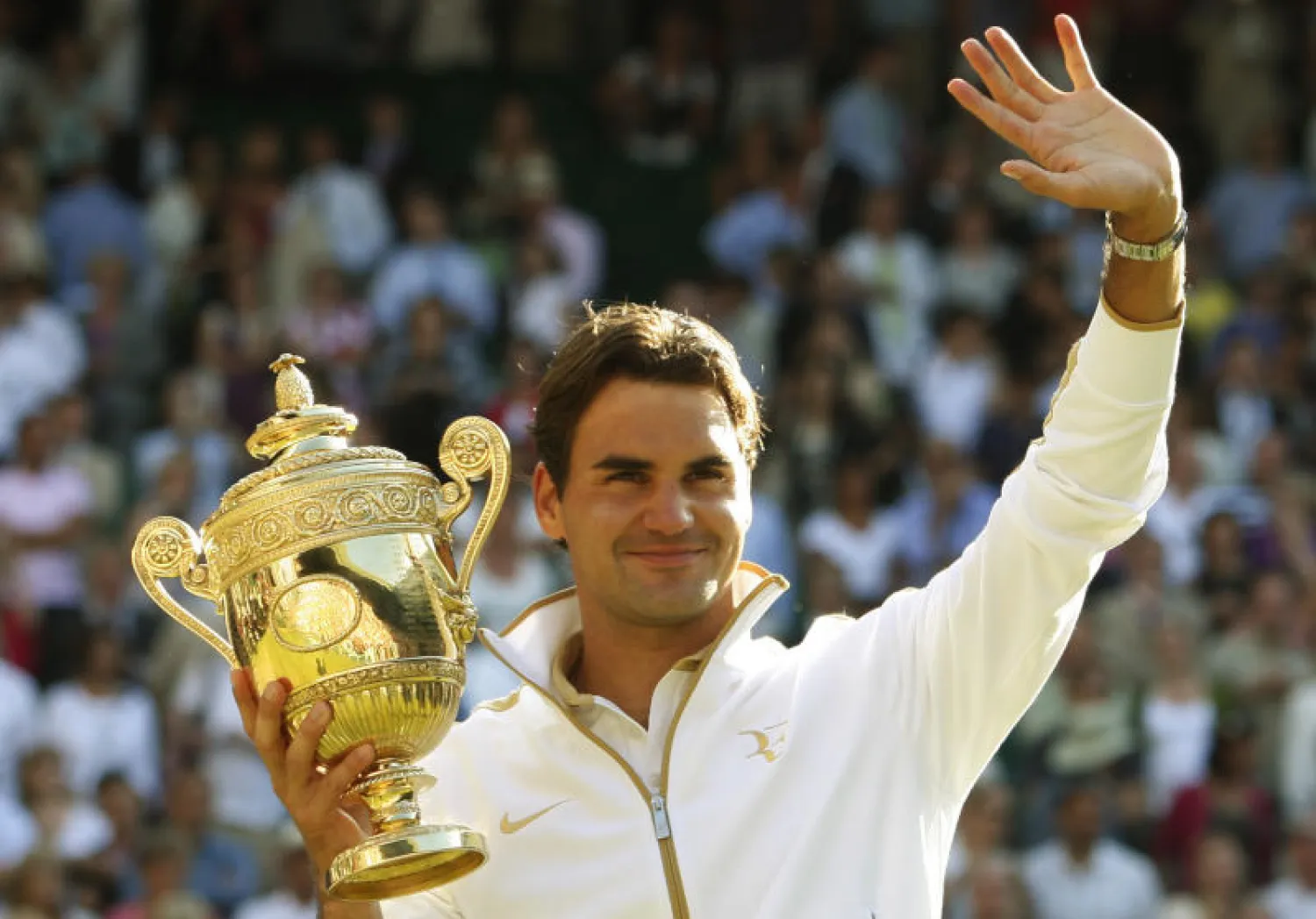 روجيه فيدرر يحمل كأس بطولة ويمبلدون عام 2009 (أ.ب)