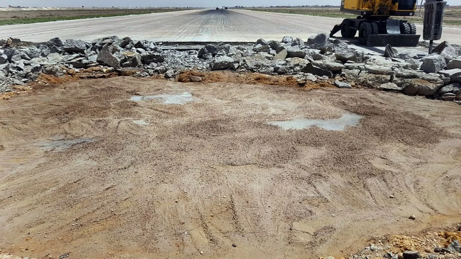 This file photo released by the Syrian official news agency SANA, shows a bulldozer working on a damaged runway of the Damascus International Airport, which was hit by an Israeli airstrike, in Damascus, Syria, June 12, 2022. (SANA via AP)