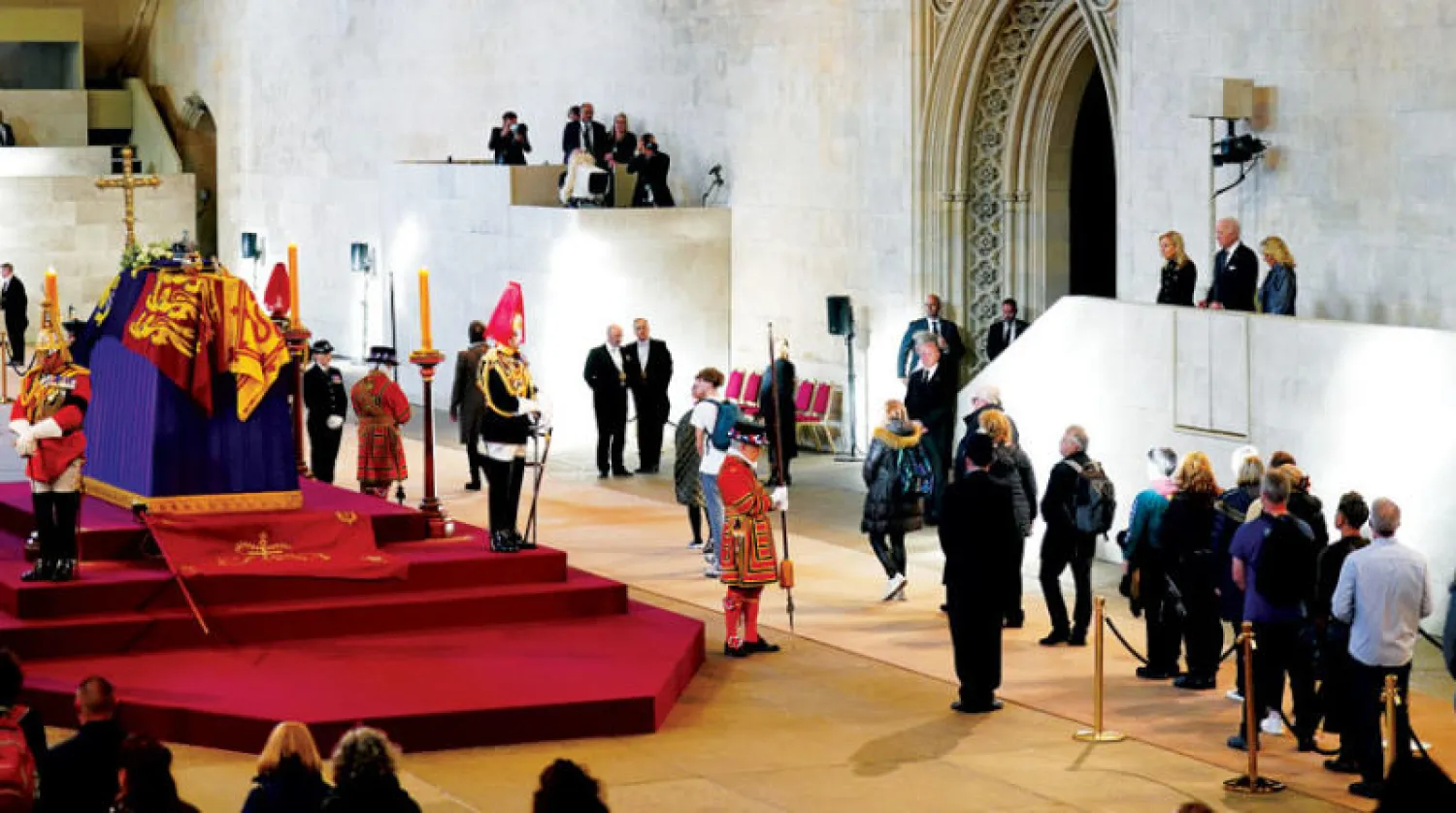 الرئيس الأميركي جو بايدن وزوجته يلقيان نظرة الوداع على نعش الملكة إليزابيث أمس (أ.ف.ب)