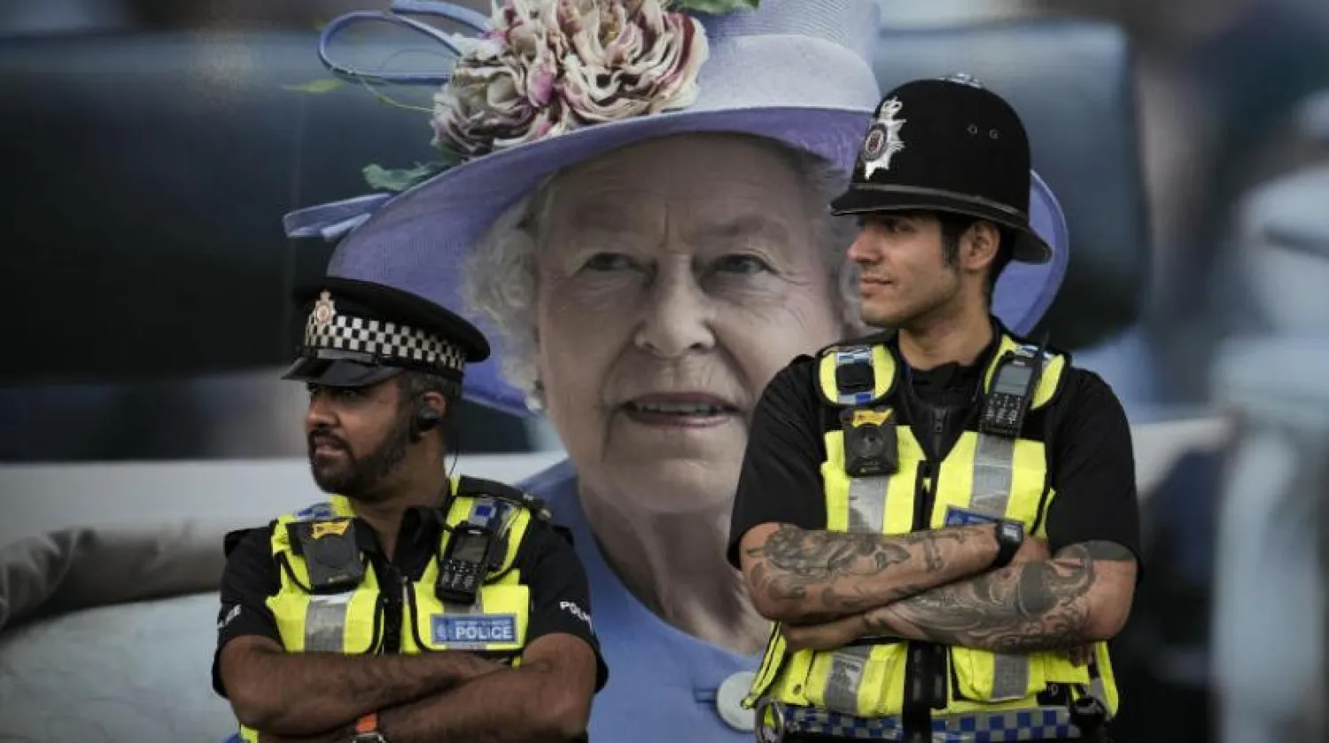 İngiliz polisleri Londra’da Kraliçe 2. Elizabeth’in fotoğrafının önünde (AP)