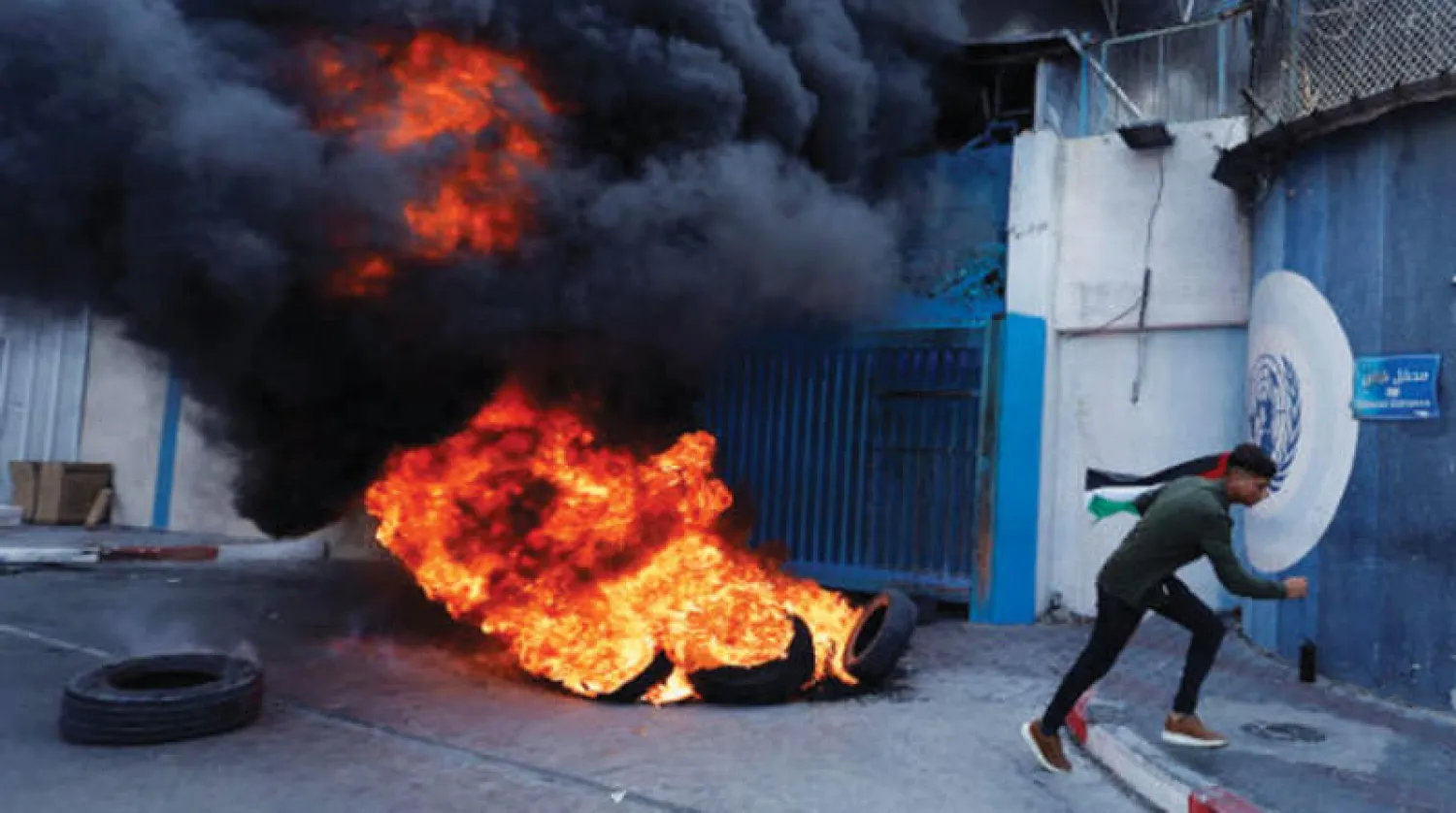 إطارات تحترق خارج مقر «أونروا» في غزة أمس (رويترز)