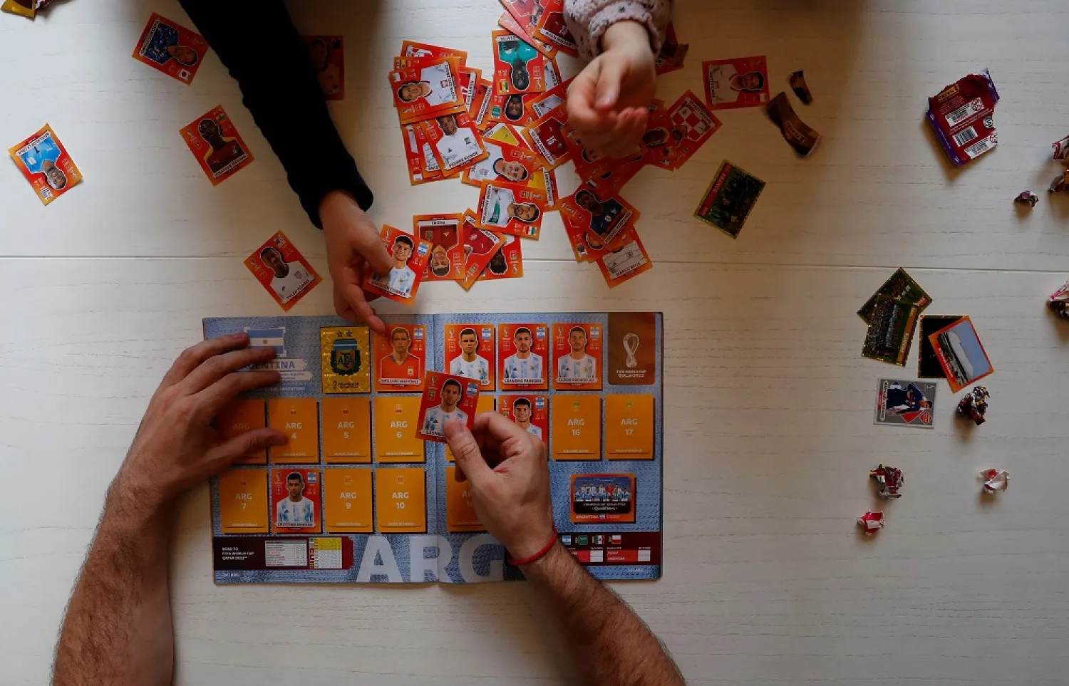 Lucas Perrone, 39, pastes football World Cup stickers with his kids in Buenos Aires, Argentina September 16, 2022. (Reuters)