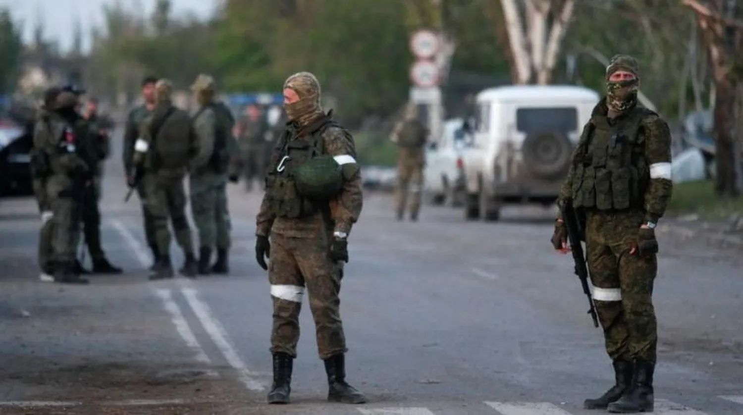Service members of pro-Russian troops stand guard on a road before the expected evacuation of wounded Ukrainian soldiers from the besieged Azovstal steel mill in the course of Ukraine-Russia conflict in Mariupol, Ukraine May 16, 2022. REUTERS/Alexander Ermochenko
