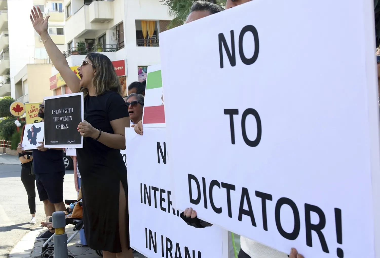 People shout slogans during a protest against the death of Iranian Mahsa Amini, outside the Iranian Embassy, in Nicosia, Cyprus, Sunday, Sept. 25, 2022. (AP)