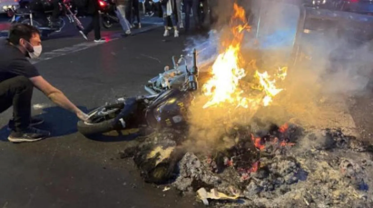 Mahsa Amini adlı genç kızın ölümünün ardından düzenlenen protestolarda İran polisine ait bir motosiklet yakıldı (AP)