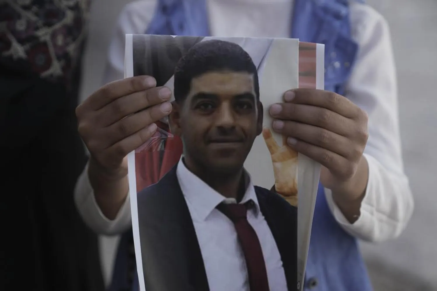 A daughter of Palestinian Mohammed Abu Kafieh holds his photo at his family house in the West Bank village of Beit Ijza on Sunday, Sept. 25, 2022 a day after he was shot and killed by Israeli forces in what Israeli army claimed was a ramming attack. Abu Kafieh's family rejected the army claim as "total lies." (AP Photo/Mahmoud Illean)
