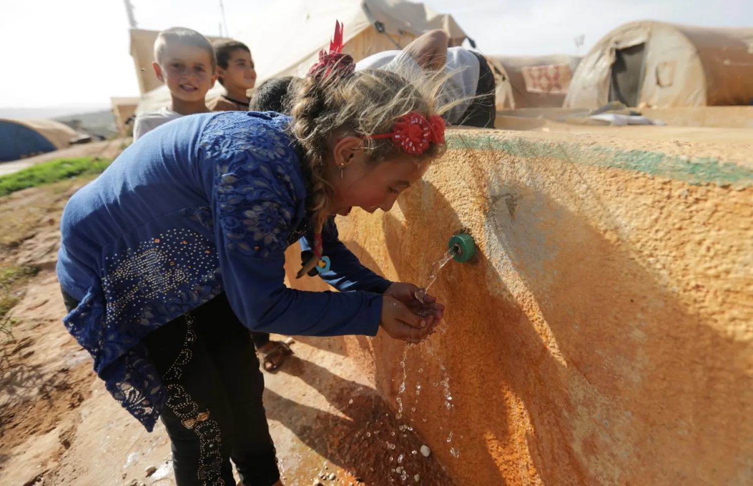 An internally displaced Syrian girl drinks water at a camp in northern Idlib, Syria May 5, 2021. REUTERS/Khalil Ashawi/Files

