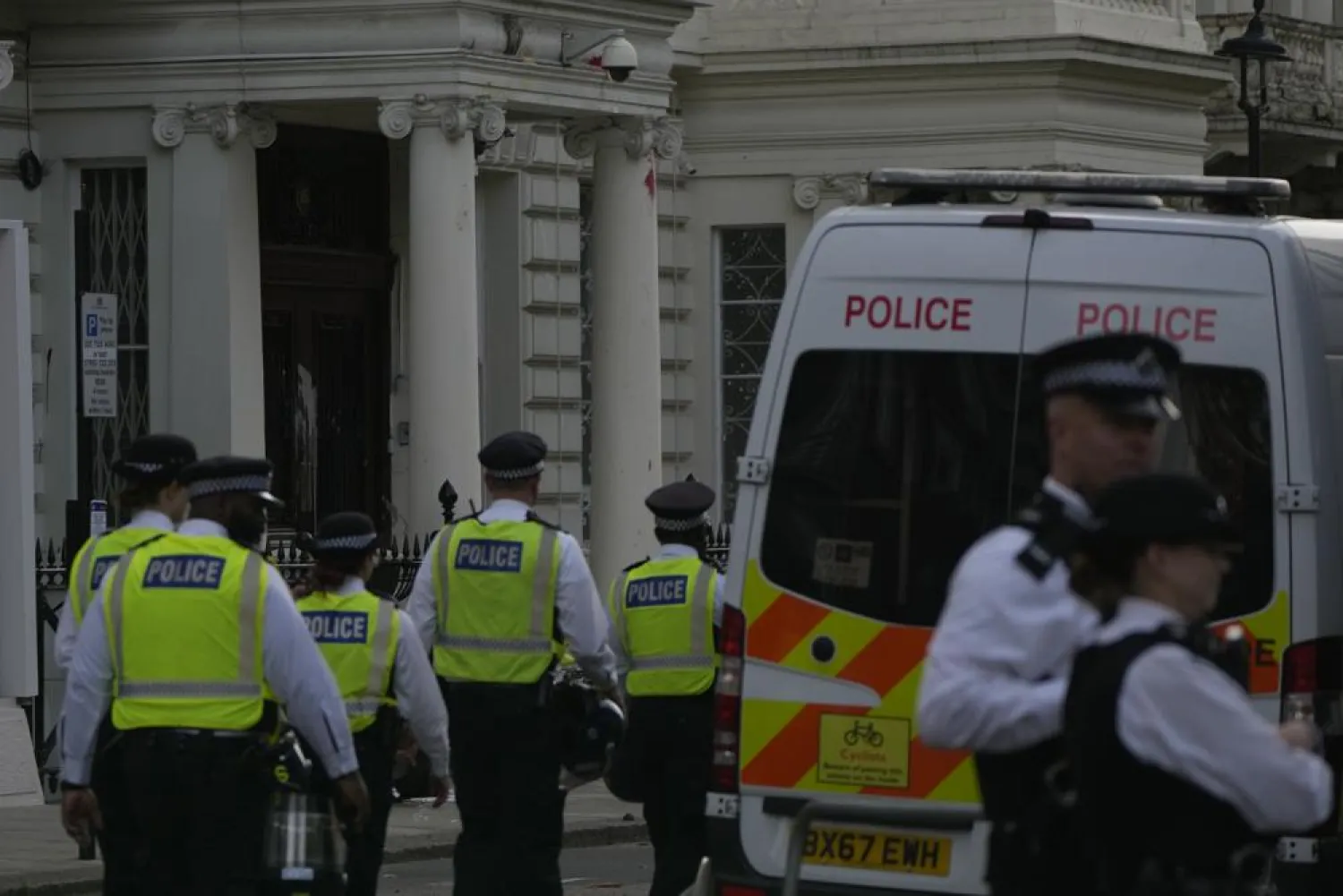 Police stand guard outside the Iranian Embassy after a small group protesters threw paint at the building in London, Sunday, Sept. 25, 2022. (AP)