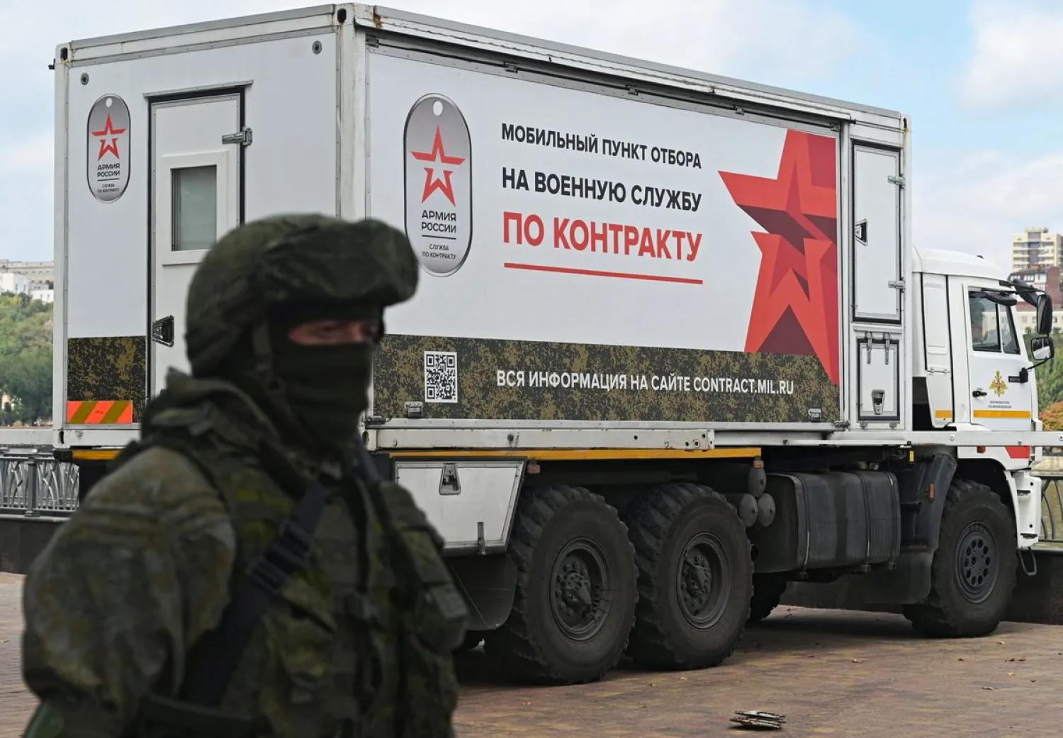 A Russian service member stands next to a mobile recruitment center for military service. Reuters