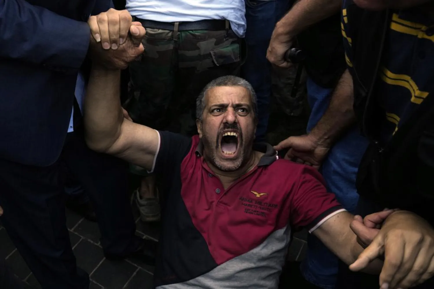 A retired army member lies on the ground and chants slogans as others try to enter to the parliament building while the legislature was in session discussing the 2022 budget in downtown Beirut, Lebanon, Monday, Sept. 26, 2022. (AP Photo/Bilal Hussein)
