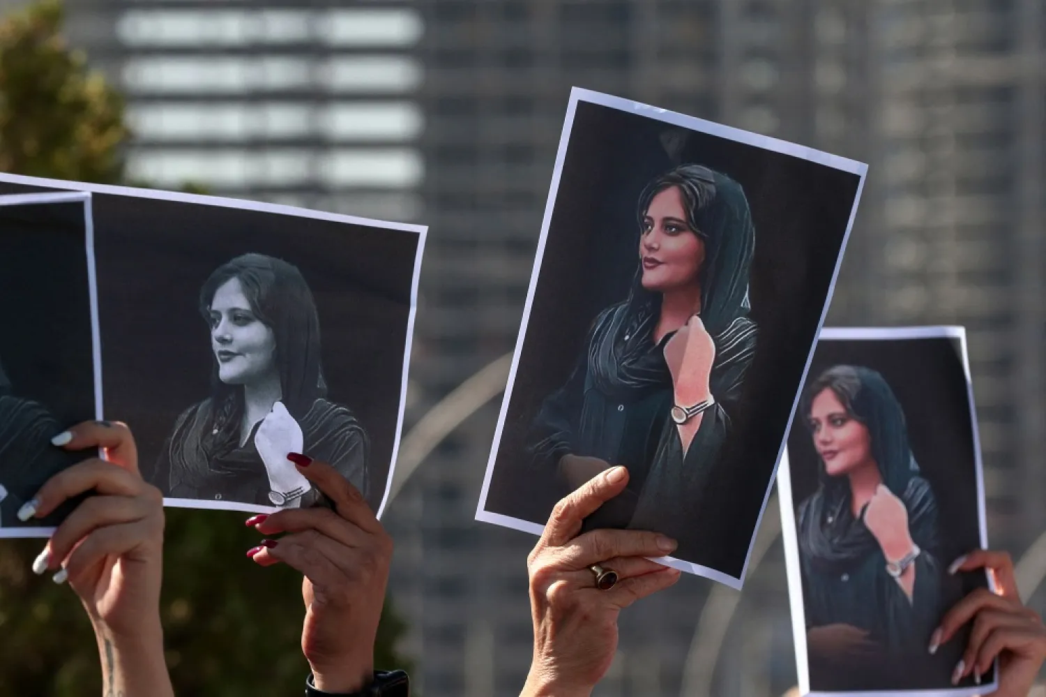 Women hold up signs depicting the image of 22-year-old Mahsa Amini, who died while in the custody of Iranian authorities, during a demonstration denouncing her death by Iraqi and Iranian Kurds outside the UN offices in Erbil, the capital of Iraq's autonomous Kurdistan region, on September 24, 2022. (AFP)