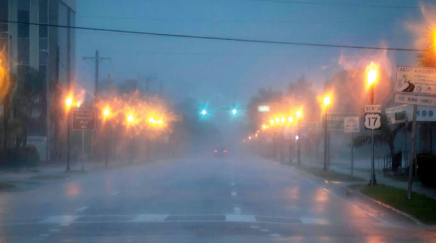 شخص يقود سيارته في بانتا غوردا بفلوريدا أمس قبيل وصول الإعصار (أ.ف.ب)