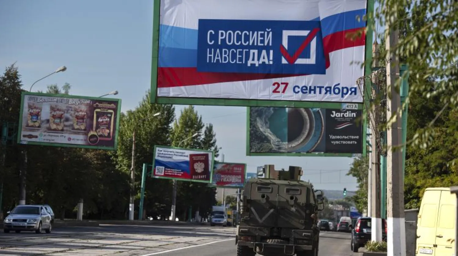 A military vehicle drives along a street with a billboard that reads: "With Russia forever, September 27", prior to a referendum in Luhansk, Luhansk People's Republic controlled by Russia-backed separatists, eastern Ukraine, Thursday, Sept. 22, 2022. (AP Photo/File)