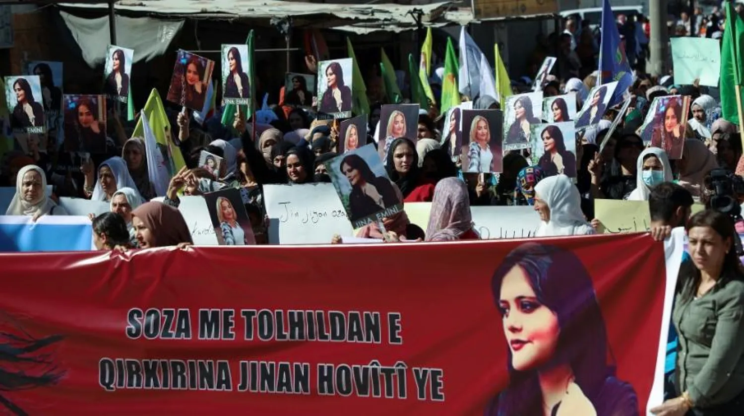 Women carry banners and pictures during a protest following the death of 22-year-old Kurdish woman Mahsa Amini in Iran, in the Kurdish-controlled city of Qamishli, northern Syria September 26, 2022. (Reuters)
