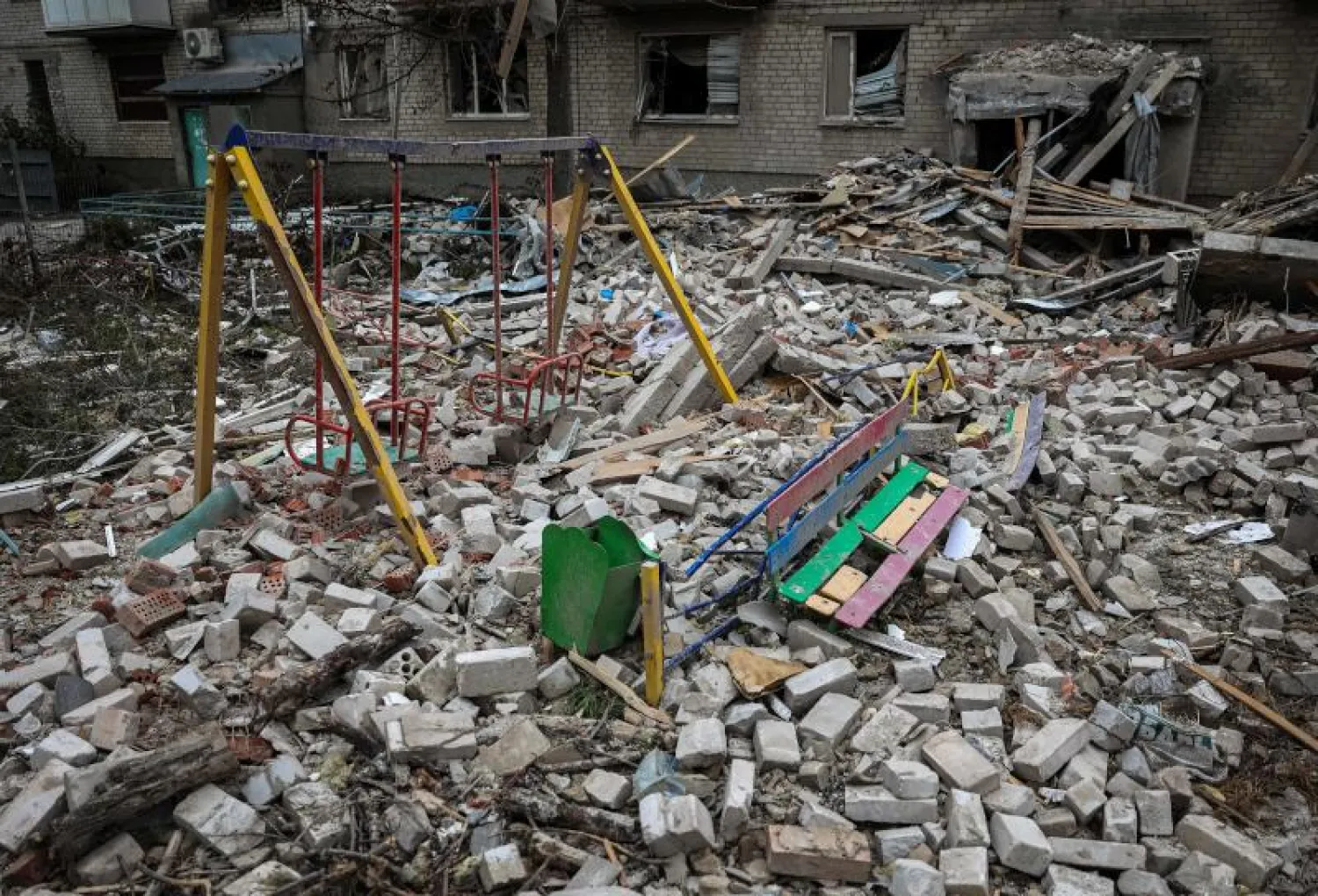 ملعب في ساحة مبنى سكني مدمر في بلدة سفياتوهيرسك بمنطقة دونيتسك وسط الغزو الروسي لأوكرانيا (أ.ف.ب)