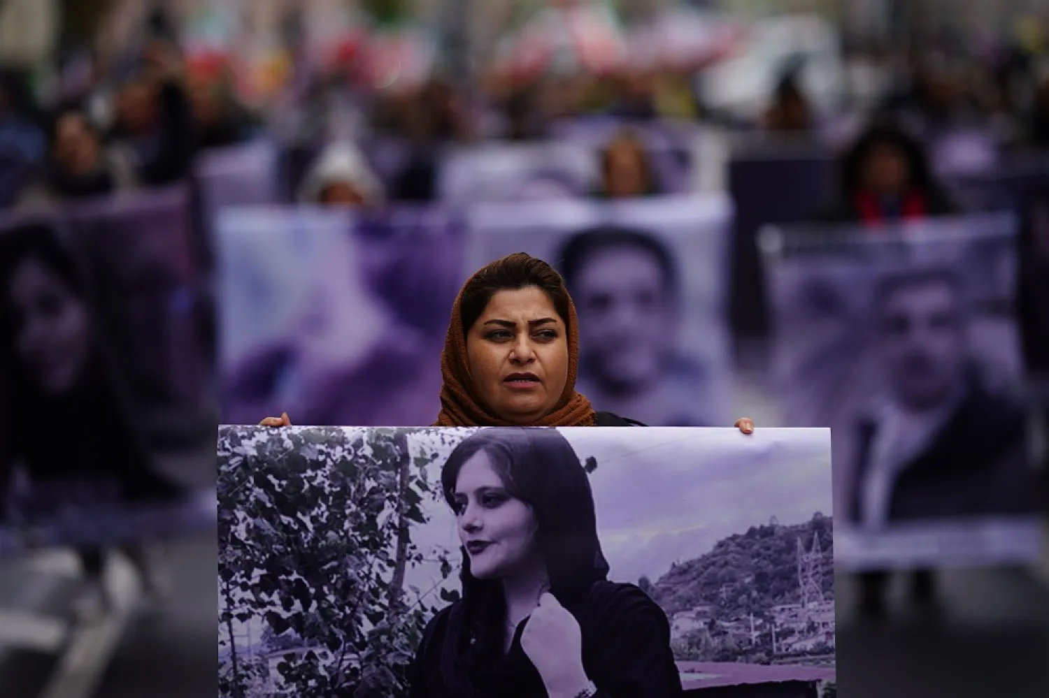 A protester carries a poster with a portrait of Mahsa Amini during a "Solidarity with the civil uprising in Iran" rally at Bebel Platz square in Berlin, Germany, 01 October 2022. (EPA)