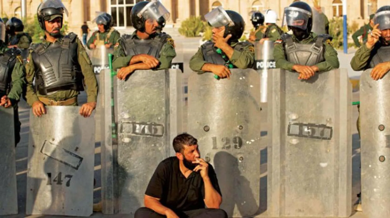 Basra’daki güvenlik güçleri önünde duran, Mukteda es-Sadr’ın bir destekçisi. (AFP)