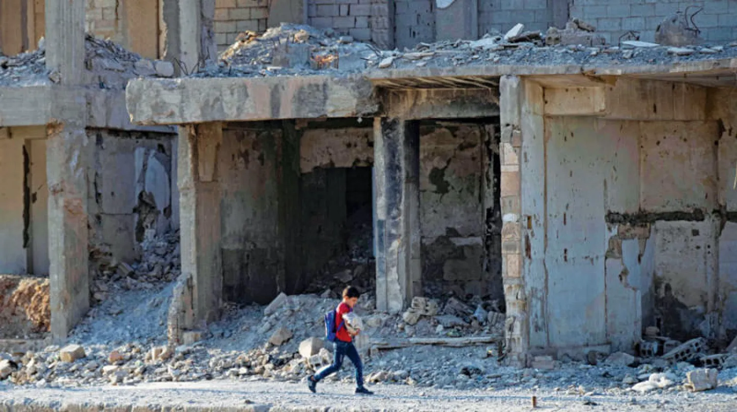 تلميذ يسير متجهاً إلى مدرسته في مدينة الرقة بشمال سوريا يوم 21 سبتمبر الماضي (أ.ف.ب)