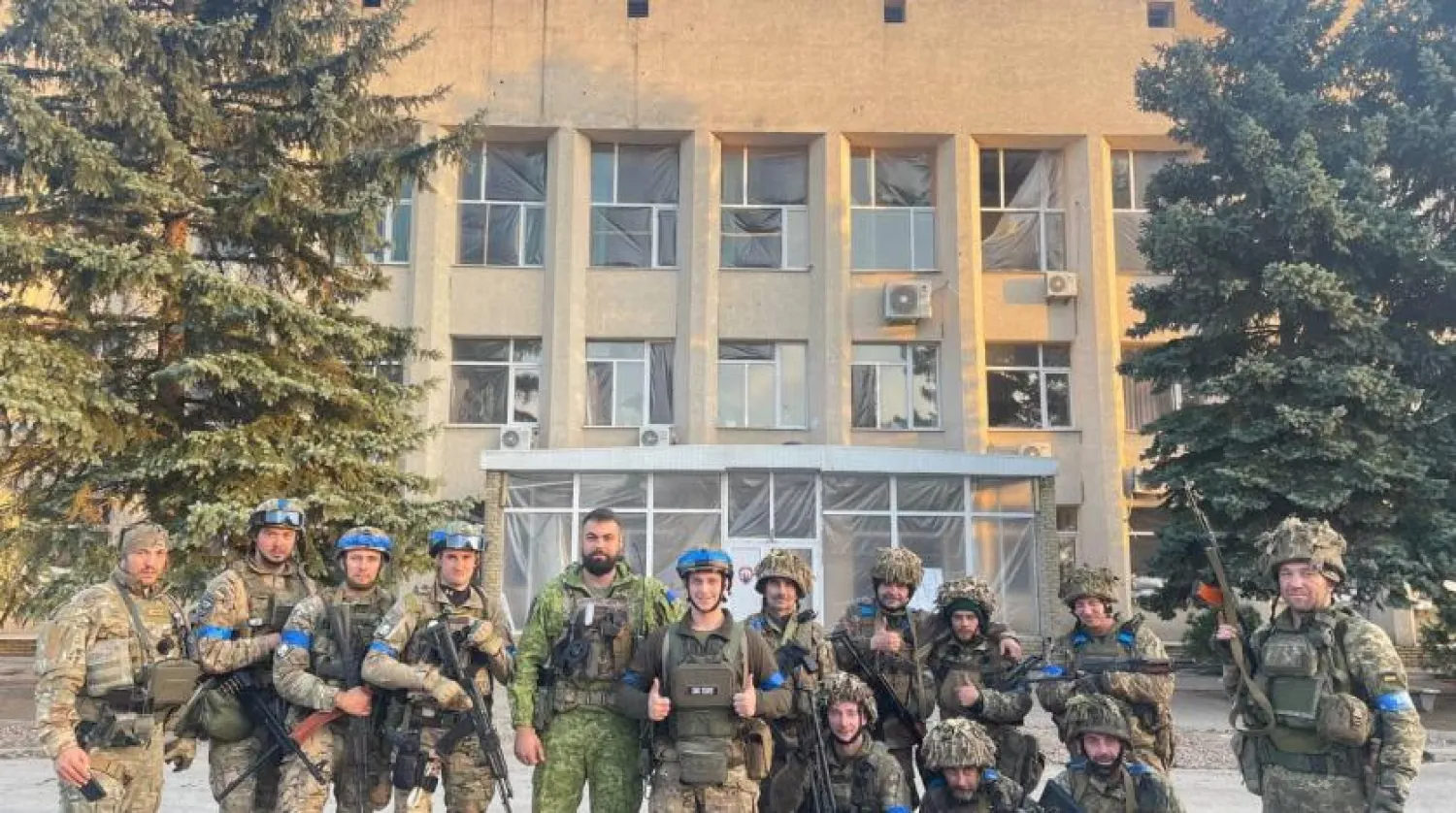 Ukraynalı bir asker Lyman polis karakolundaki bir pankartı yerinden söküyor (Reuters)