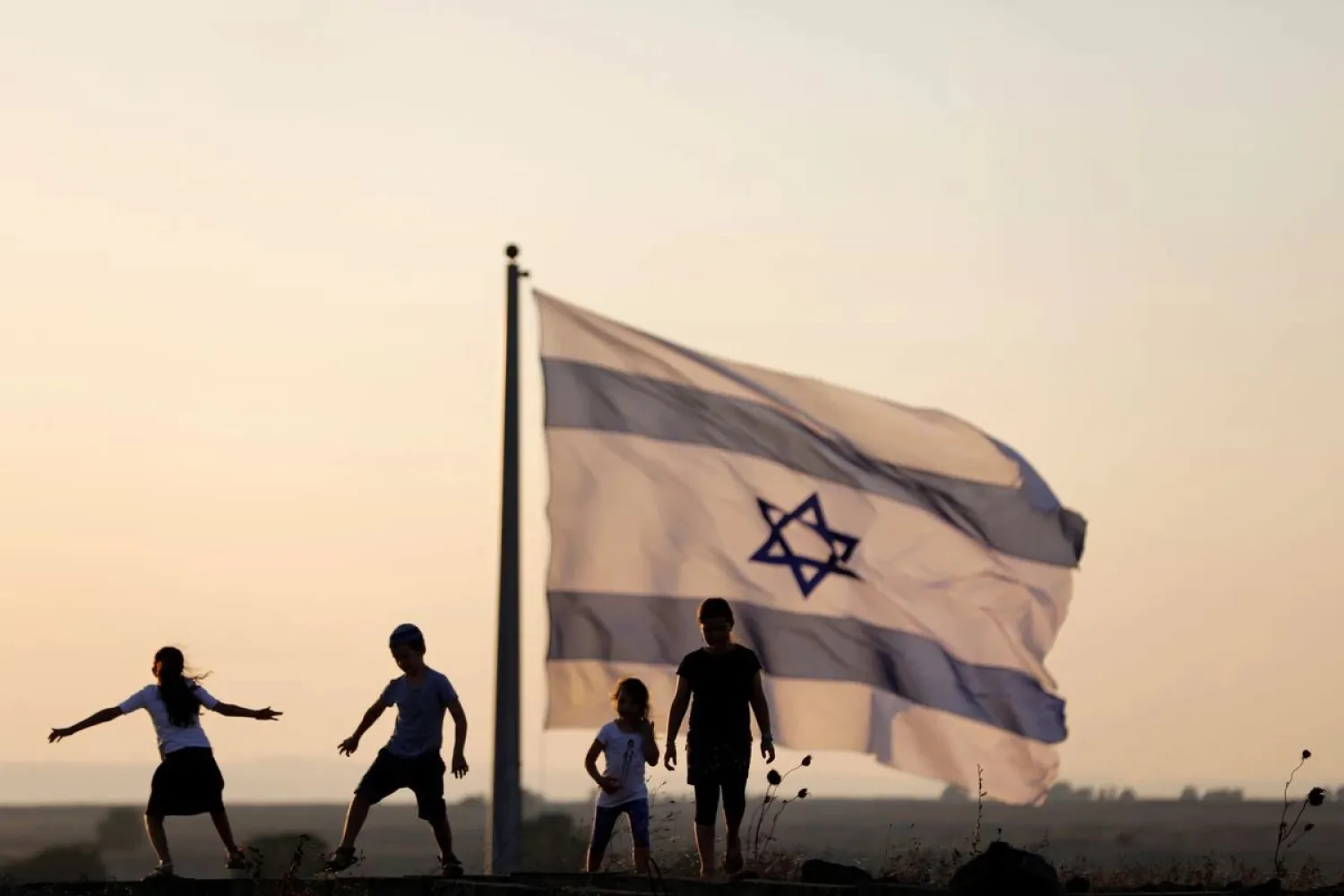 Israeli kids play next to an Israeli flag next to the Israeli Syrian border at the occupied Golan Heights, Israel July 23, 2018. REUTERS/Ronen Zvulun/File Photo
