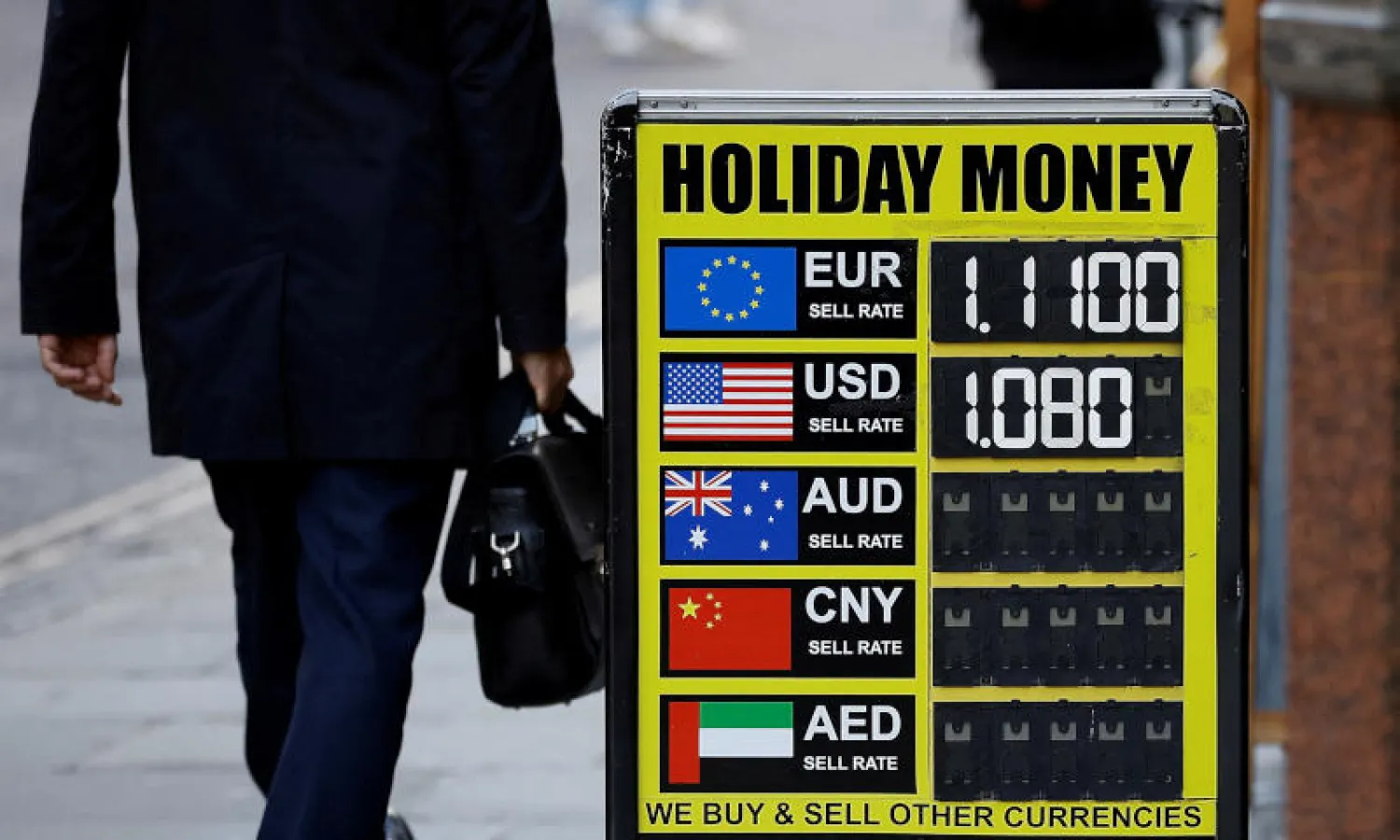 شخص يسير بجوار لوحة خارج مكتب صرافة في لندن (رويترز)