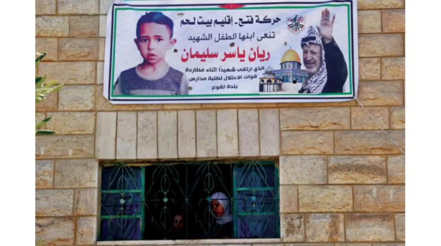 Banner carrying the image of child Rayyan Suleiman who was killed in the West Bank on September 30 (AFP)