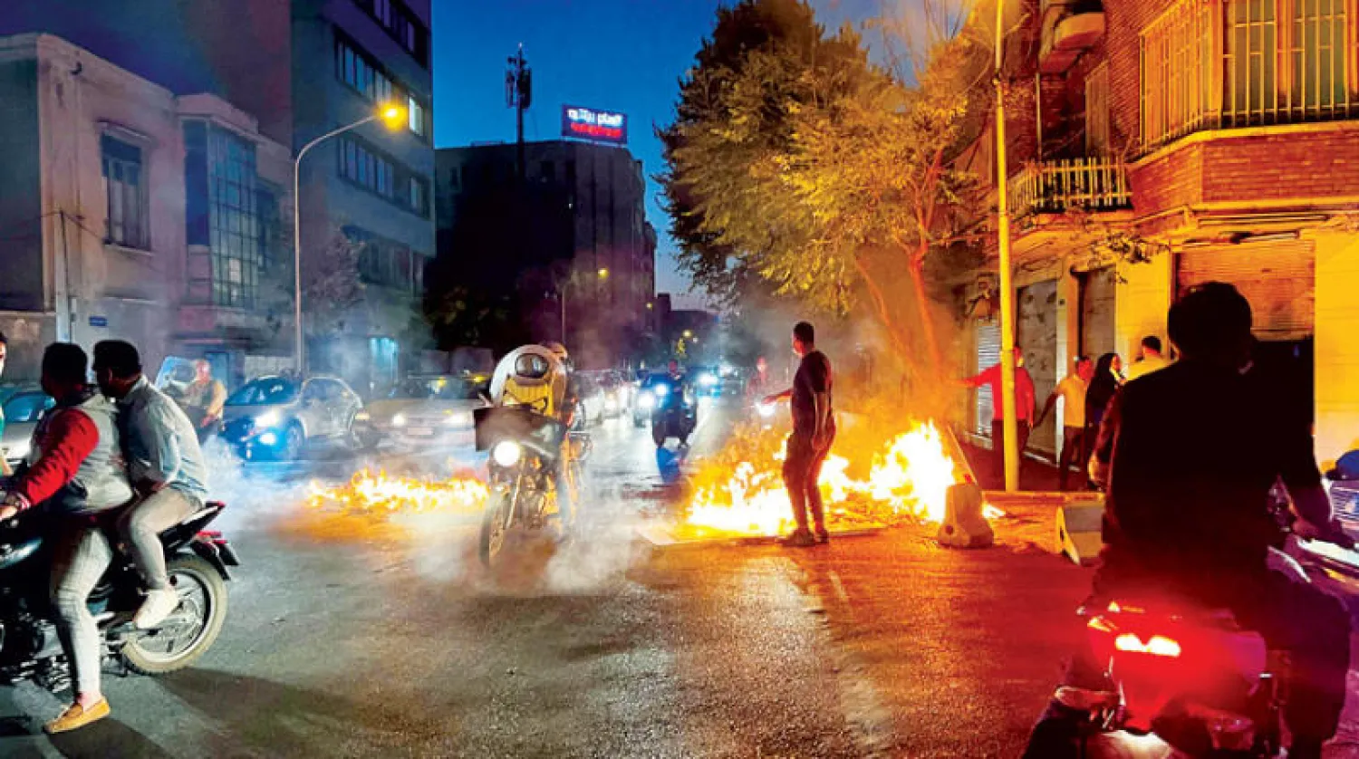 محتجون يضرمون النار في شارع لعرقلة حركة قوات الأمن وسط طهران أول من أمس (أ.ف.ب)